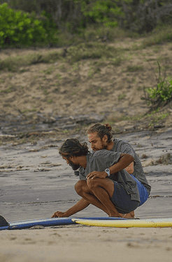 Tailslide professional surf lessons_coach giving student surfboard technique lesson on beach_technical surf coaching Sri Lanka_About