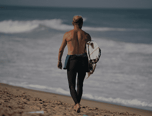 Tailslide_surfer walking with board at Madiha beach_everyone can surf Sri Lanka_our values_About