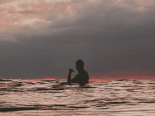 tailslide-surf-benefits-of-surfin-mental-health_Boy-surfing-sunset