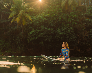 Tailslide technical surf cooaching lessons Sri Lanka_girl surfer sitting on board at sunset in Ahangama break_learn to speak to any coach anywhere and explain your level_Coaching