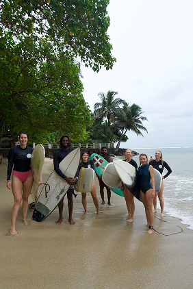 Tailslide_group of intermediate surf retreat guests smiling happy after a surf lesson in Madiha_Retreat Page